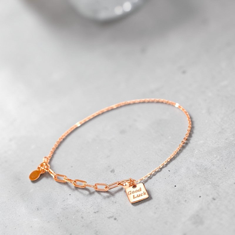 Amara Jewels rose gold plated sterling silver bracelet with a square 'Good Luck' charm and mixed chain links.