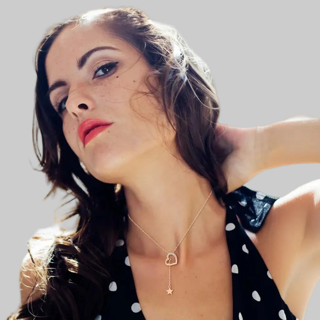 Amara Jewels rose gold tone necklace with heart pendant adorned with cubic zirconia and a dangling star charm.