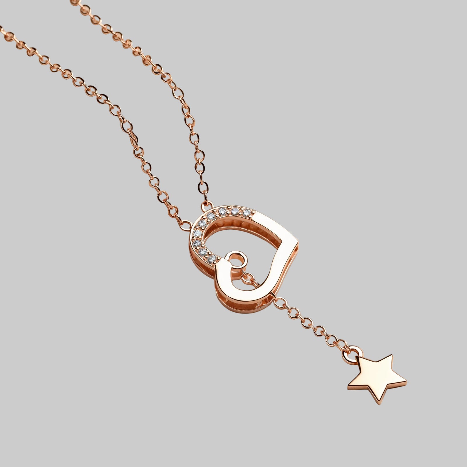 Amara Jewels rose gold tone necklace with heart pendant adorned with cubic zirconia and a dangling star charm.