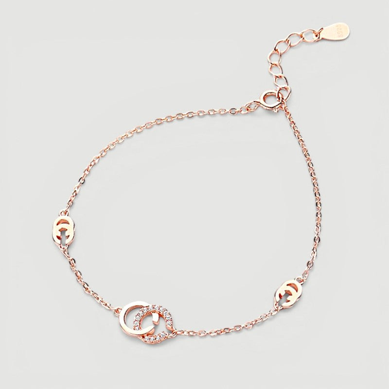 Amara Jewels rose gold 925 sterling silver adjustable chain bracelet with interlocking circles, one adorned with cubic zirconia.