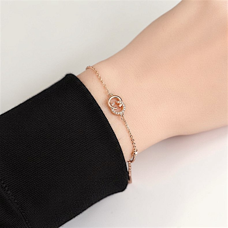 Amara Jewels rose gold 925 sterling silver adjustable chain bracelet with interlocking circles, one adorned with cubic zirconia.