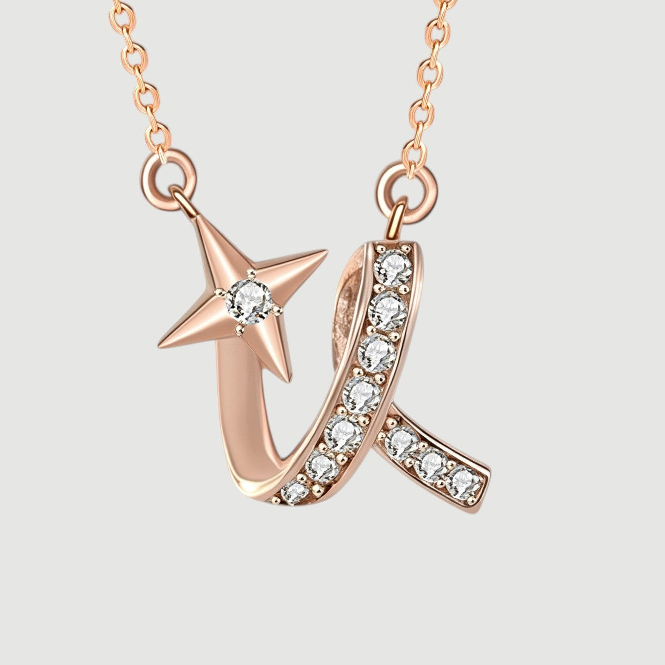 Amara Jewels rose gold necklace with a shooting star charm adorned with a diamond and a curved ribbon embellished with small diamonds.