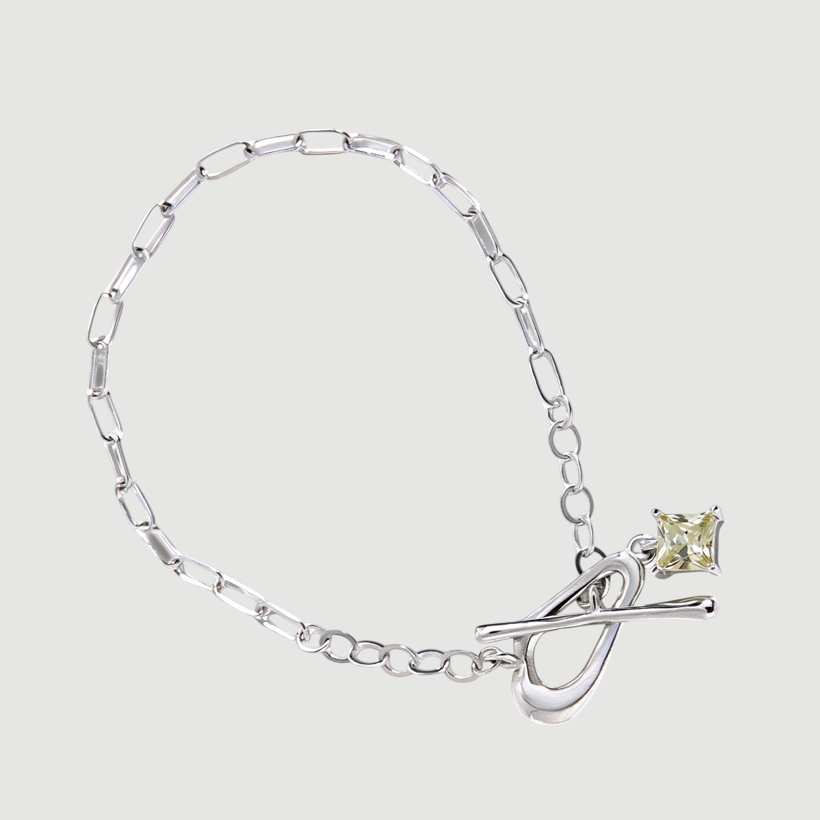Amara Jewels sterling silver bracelet with paperclip chain, T-bar clasp, and a square citrine-colored charm.