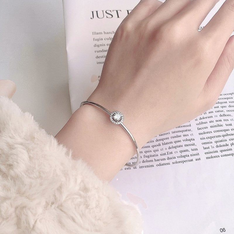 Amara Jewels 925 sterling silver bangle with a sparkling crystal centerpiece, perfect for adding elegance to any outfit.