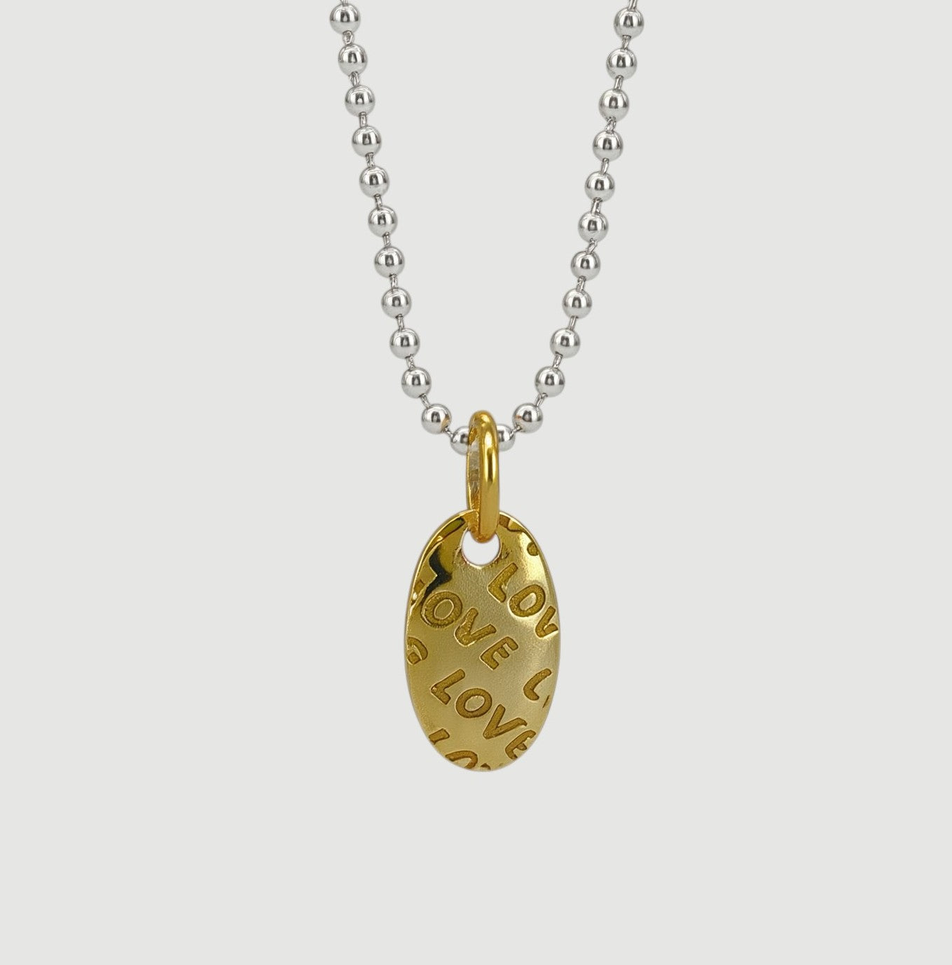 Amara Jewels sterling silver ball chain necklace with textured gold oval pendant embossed with 'LOVE'.