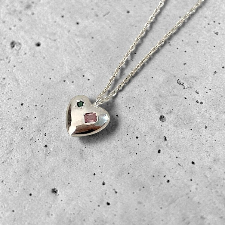 Amara Jewels sterling silver heart charm necklace with engraved red and green shapes.