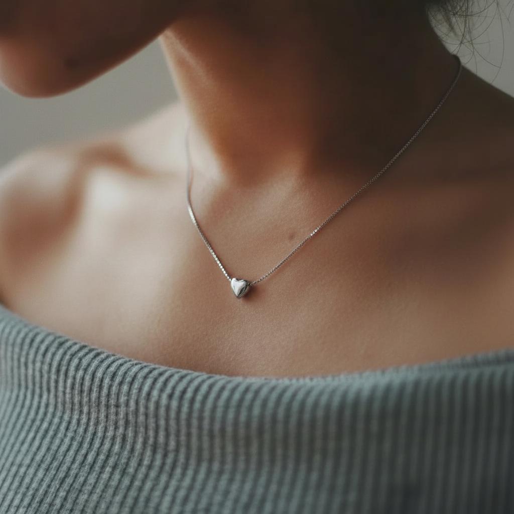 Amara Jewels minimalist sterling silver heart necklace with a delicate box chain. Polished silver pendant.
