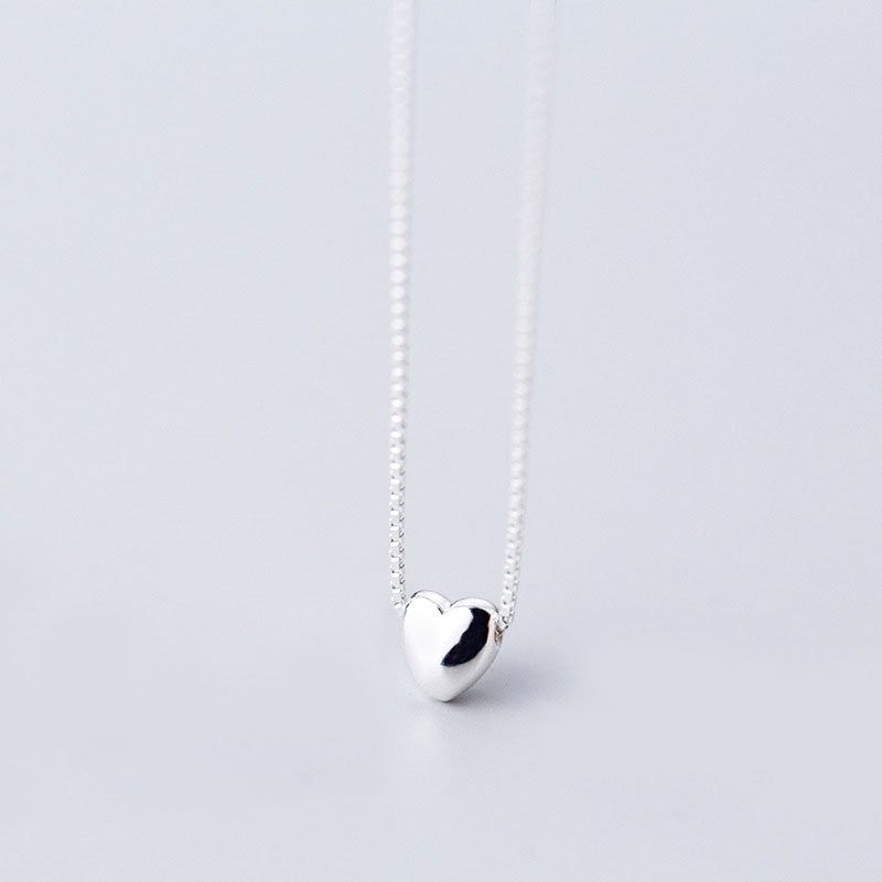 Amara Jewels minimalist sterling silver heart necklace with a delicate box chain. Polished silver pendant.