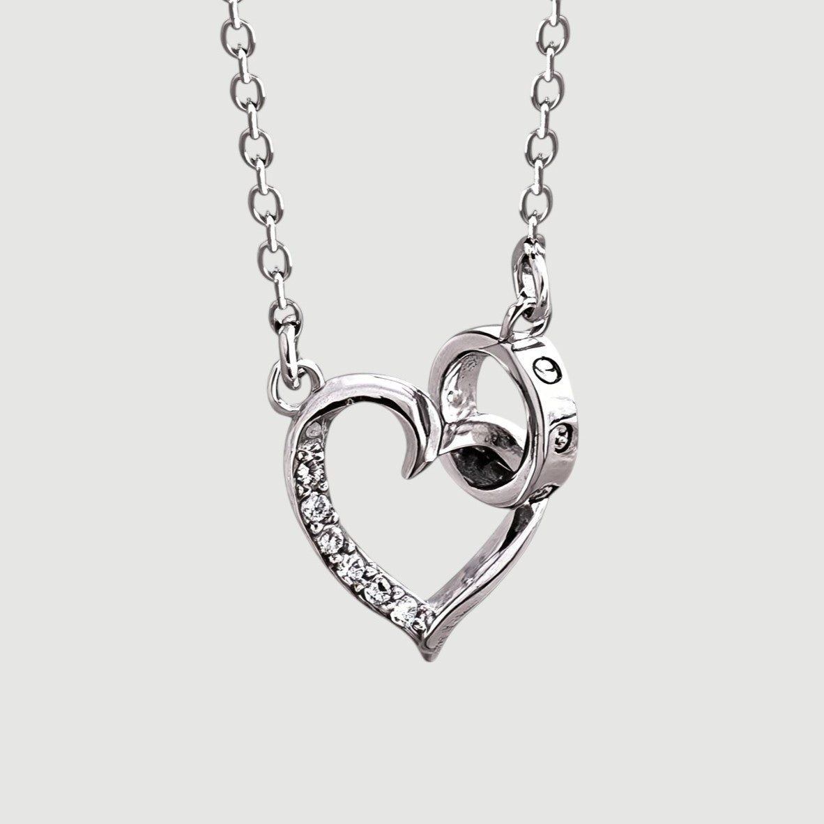 Amara Jewels silver 925 sterling necklace with a delicate heart pendant featuring crystal accents and an intertwined ring detail.