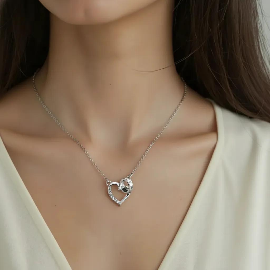 Amara Jewels silver 925 sterling necklace with a delicate heart pendant featuring crystal accents and an intertwined ring detail.