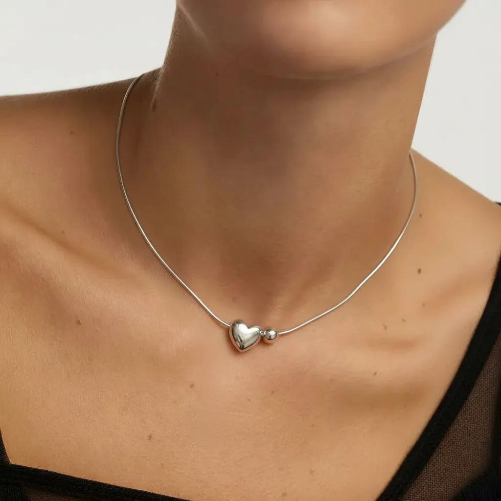 Amara Jewels sterling silver necklace with a heart charm and a small sphere.