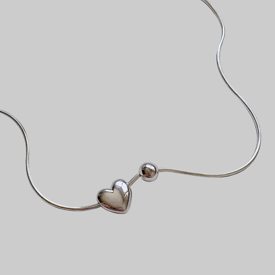 Amara Jewels sterling silver necklace with a heart charm and a small sphere.