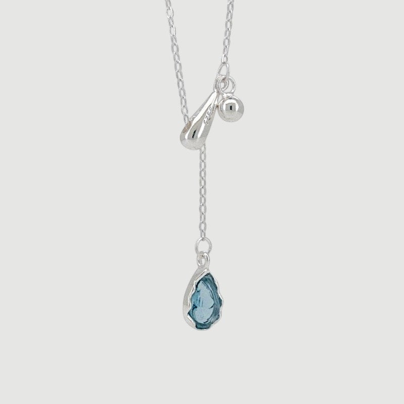Amara Jewels sterling silver necklace with a blue teardrop gemstone pendant and silver charms.