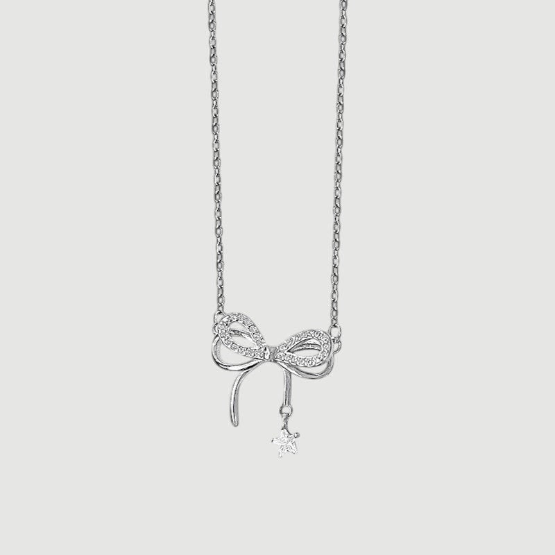 Amara Jewels sterling silver necklace with a sparkling bow charm and dangling star pendant.