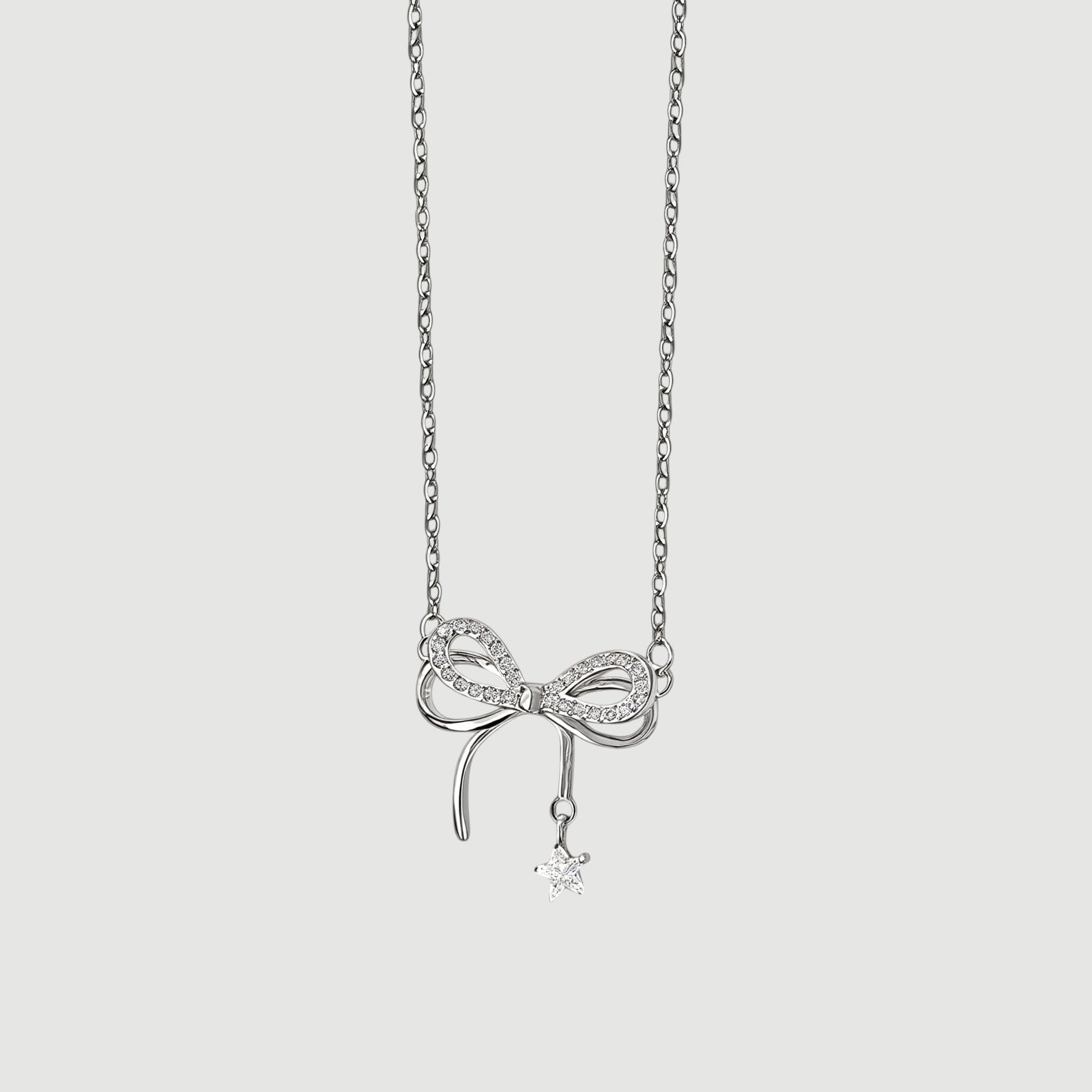 Amara Jewels sterling silver necklace with a sparkling bow charm and dangling star pendant.