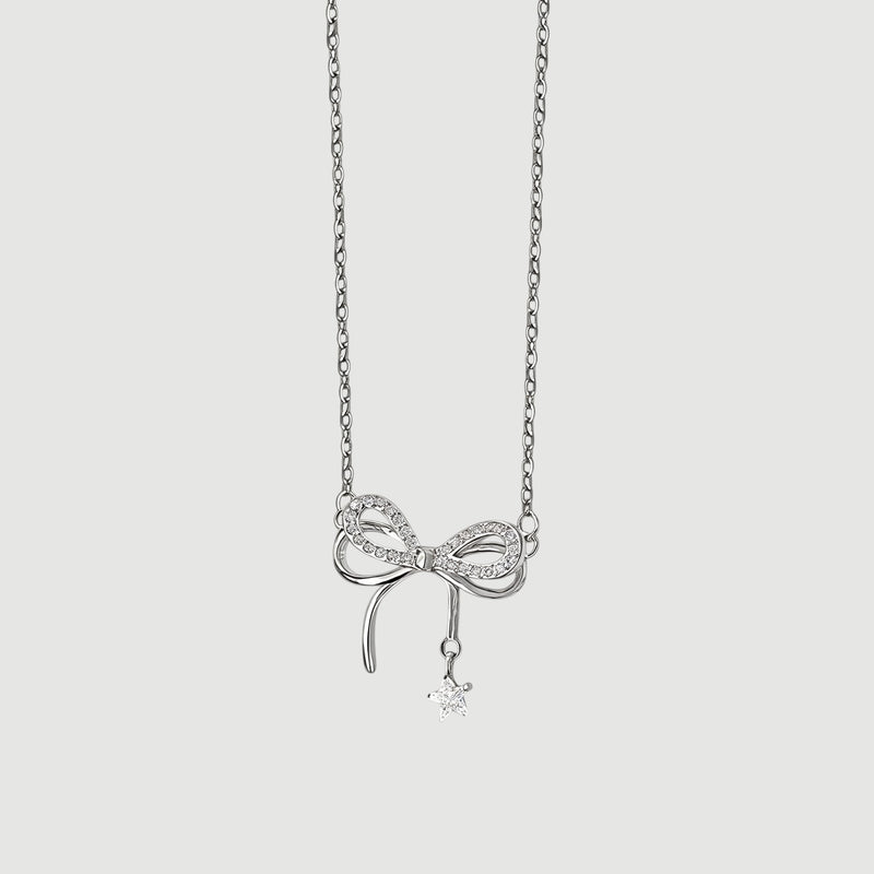 Amara Jewels sterling silver necklace with a sparkling bow charm and dangling star pendant.