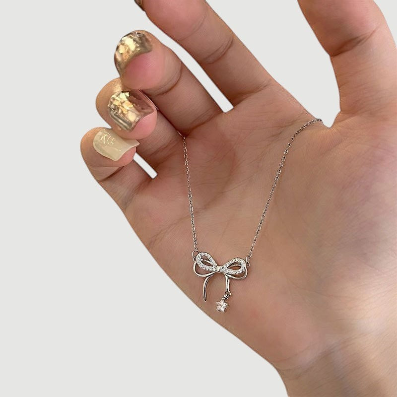 Amara Jewels sterling silver necklace with a sparkling bow charm and dangling star pendant.