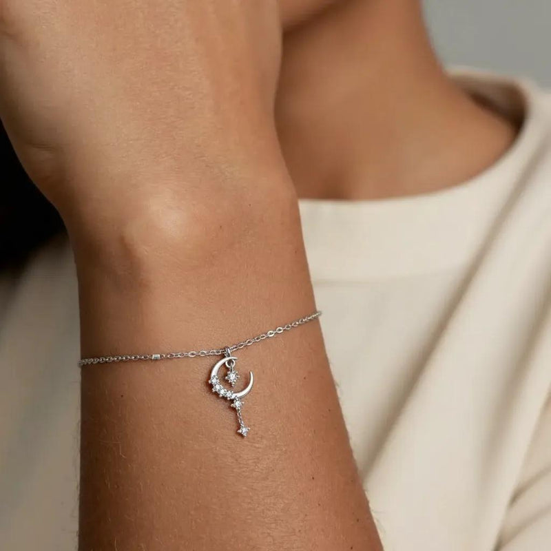 Amara Jewels sterling silver bracelet with a crescent moon and star charm, encrusted with cubic zirconia. Features a delicate chain and adjustable clasp.