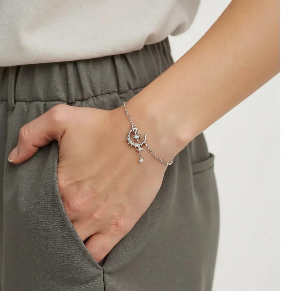 Amara Jewels sterling silver bracelet with a crescent moon and star charm, encrusted with cubic zirconia. Features a delicate chain and adjustable clasp.