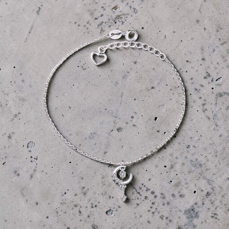 Amara Jewels sterling silver bracelet with a crescent moon and star charm, encrusted with cubic zirconia. Features a delicate chain and adjustable clasp.