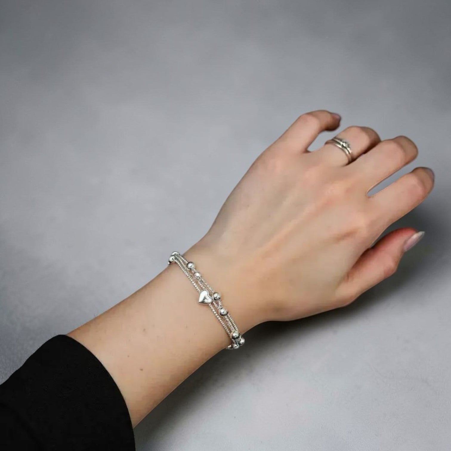 Amara Jewels delicate dual-layered sterling silver bracelet with heart charms and small beads.