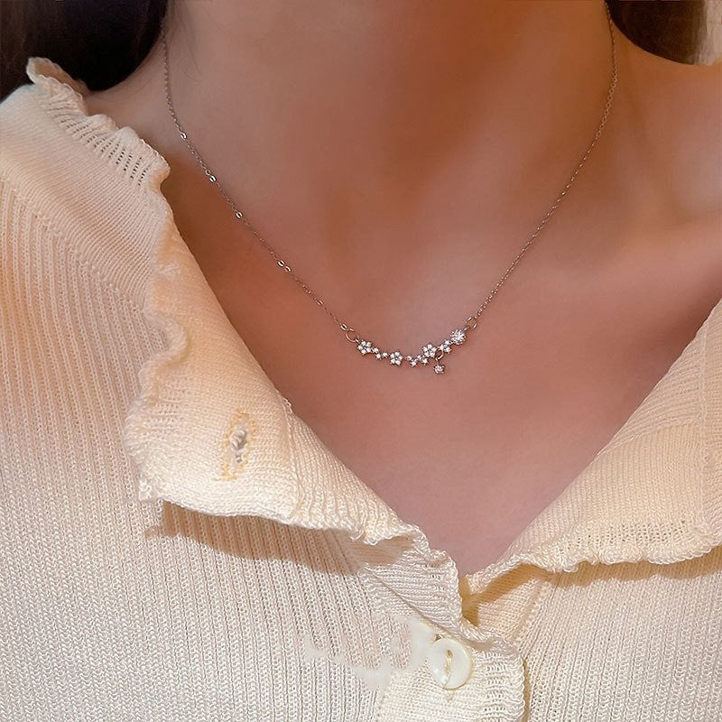 Amara Jewels 925 sterling silver necklace with delicate floral charms and sparkling cubic zirconia stones.