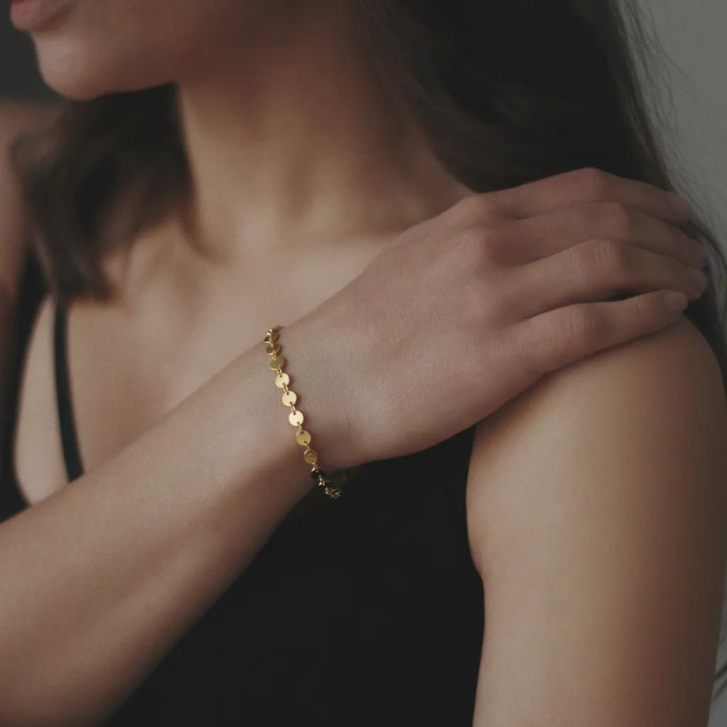 Amara Jewels gold-plated sterling silver bracelet with interlocking polished discs, adjustable chain, and lobster clasp.