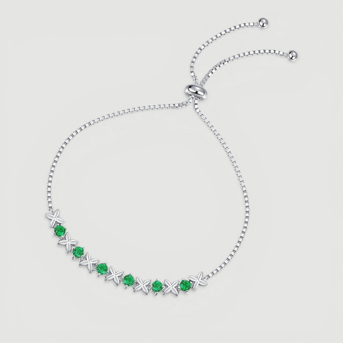 Amara Jewels sterling silver bracelet with green gemstones set in a flower design. Adjustable slider clasp.