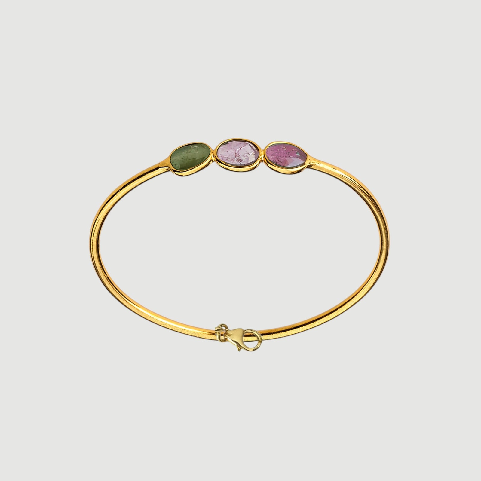 Amara Jewels 18K gold vermeil wrap bracelet with three bezel-set oval tourmaline gemstones in pink, green, and red.