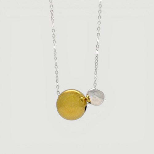 Amara Jewels two-tone sphere pendant necklace with polished silver chain, featuring a large gold sphere and a smaller silver sphere.